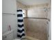 Bathroom with a striped shower curtain and tiled shower with updated fixtures at 14712 Eagles Crossing Dr, Orlando, FL 32837
