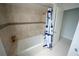 Bathroom with a tiled shower-tub combination and striped shower curtain at 14712 Eagles Crossing Dr, Orlando, FL 32837