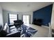 Bright living room featuring modern blue accent wall, comfortable sofas, and a stylish rug at 14712 Eagles Crossing Dr, Orlando, FL 32837