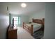 Cozy main bedroom featuring a wooden bed frame, dresser, and soft natural light at 14712 Eagles Crossing Dr, Orlando, FL 32837