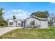 Charming single-story home with well-maintained yard, long driveway, and neutral gray paint at 1499 Courtland Blvd, Deltona, FL 32738