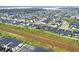 An aerial view shows a community, with orderly street layouts and uniform houses near grassy spaces at 17052 Cercis Loop, Clermont, FL 34711