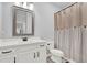 Bathroom with single vanity, mirror, and toilet behind a shower curtain at 17052 Cercis Loop, Clermont, FL 34711