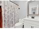 Modern bathroom with floral shower curtain, white vanity and matte black hardware at 17052 Cercis Loop, Clermont, FL 34711