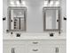 Double sink bathroom with quartz counters, dual mirrors and modern black fixtures at 17052 Cercis Loop, Clermont, FL 34711