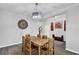 Bright dining room features modern light fixture and a unique wooden table set at 17052 Cercis Loop, Clermont, FL 34711