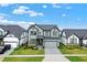 This modern home features two-stories, gray siding, stone accents, a manicured lawn and a paved driveway at 17052 Cercis Loop, Clermont, FL 34711