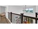 Bright, neutral hallway with wooden floors and modern railing looking out on a tree lined street at 17052 Cercis Loop, Clermont, FL 34711