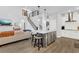 The stylish open kitchen features a large island, bar stool seating, and modern stainless-steel appliances at 17052 Cercis Loop, Clermont, FL 34711