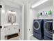 Laundry room and bathroom feature a modern washer, dryer, and vanity at 17052 Cercis Loop, Clermont, FL 34711