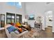 Cozy living room featuring high ceilings, hardwood floors, ample natural light, and stylish furnishings at 17052 Cercis Loop, Clermont, FL 34711