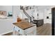 Open concept living space boasts stairs with black metal railing, a kitchen, and wood floors at 17052 Cercis Loop, Clermont, FL 34711