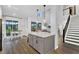 Open concept living space boasts stairs with black metal railing, a kitchen and dining area at 17052 Cercis Loop, Clermont, FL 34711