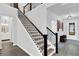 Staircase with dark wood and black metal railing leads to the second floor at 17052 Cercis Loop, Clermont, FL 34711