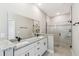 Bathroom featuring double vanity with granite countertop and a tiled walk-in shower with glass enclosure at 1870 Blackwelder Rd, De Leon Springs, FL 32130