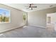 Spacious bedroom with plush carpet, ceiling fan, and two windows providing ample natural light at 1870 Blackwelder Rd, De Leon Springs, FL 32130