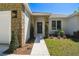Charming home entrance featuring stone accents, a dark front door, and well-manicured landscaping at 1870 Blackwelder Rd, De Leon Springs, FL 32130