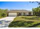 Charming single-story home featuring a two-car garage, stone accents, and a well-manicured lawn at 1870 Blackwelder Rd, De Leon Springs, FL 32130