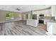 Open-concept kitchen with white cabinets, stainless steel appliances, granite countertops, and modern flooring at 1870 Blackwelder Rd, De Leon Springs, FL 32130