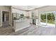 Open kitchen with stainless appliances, granite counters, gray flooring, and sliding glass doors to the patio at 1870 Blackwelder Rd, De Leon Springs, FL 32130