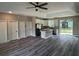 Open concept living area with gray wood-look flooring flowing into a modern kitchen with an island at 1870 Blackwelder Rd, De Leon Springs, FL 32130