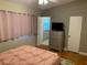 Comfortable bedroom featuring neutral tones, a decorative dresser, and an ensuite bathroom at 217 Wilmer Ave, Orlando, FL 32811