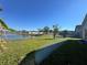 Backyard featuring a lawn and a fence with scenic views of a pond and neighborhood homes at 235 Tuscany Pointe Ave, Orlando, FL 32807