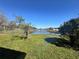 Backyard featuring a well-maintained lawn, a fence, a pond and plenty of space at 235 Tuscany Pointe Ave, Orlando, FL 32807