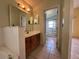 Hallway view of bathroom with tile flooring, wood cabinets and bath/shower combo at 235 Tuscany Pointe Ave, Orlando, FL 32807