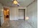 Neutral bedroom with tile floors, ceiling fan with light, and open closet with access to attached bathroom at 235 Tuscany Pointe Ave, Orlando, FL 32807