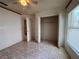 Bright bedroom with tile flooring, a ceiling fan, and an open closet offering ample storage space at 235 Tuscany Pointe Ave, Orlando, FL 32807