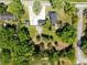 Aerial view of a home with a large yard, mature trees, and an expansive driveway in a peaceful, green neighborhood at 2431 Narcissus Ave, Sanford, FL 32771