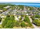 Expansive aerial view of a residential neighborhood with waterfront homes along a tranquil bay, lush greenery, and blue skies at 2431 Narcissus Ave, Sanford, FL 32771