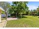 Expansive backyard featuring a brick patio and mature trees that provide ample shade at 2431 Narcissus Ave, Sanford, FL 32771