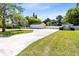 Long driveway leads to a detached two-car garage, complemented by well-kept lawn and mature trees at 2431 Narcissus Ave, Sanford, FL 32771