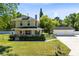 Inviting two-story home with a front porch, lush landscaping, and a detached two-car garage at 2431 Narcissus Ave, Sanford, FL 32771