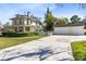 View of a two-story yellow home with a detached three-car garage and a spacious concrete driveway at 2431 Narcissus Ave, Sanford, FL 32771