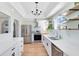 Renovated kitchen featuring stainless steel appliances, white cabinets, a view to the living area, and wood floors at 2431 Narcissus Ave, Sanford, FL 32771