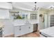 Charming kitchen features white cabinetry, stainless steel appliances, open shelving, and wood-look floors at 2431 Narcissus Ave, Sanford, FL 32771