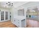 Bright kitchen area with white cabinets, granite counters and chandelier lighting leading into a dining area at 2431 Narcissus Ave, Sanford, FL 32771