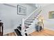 White staircase with black steps and white risers, complimented by light hardwood floors and tasteful decor at 2431 Narcissus Ave, Sanford, FL 32771
