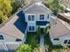 An elevated aerial view of the luxury home featuring a beautifully landscaped yard, mature trees, and a brick driveway at 254 Sylvan Blvd, Winter Park, FL 32789
