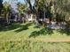 Backyard with manicured lawn, mature trees, and an outdoor fire pit near the water at 254 Sylvan Blvd, Winter Park, FL 32789