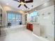 Well-lit bathroom featuring a soaking tub by a large window and a glass-enclosed shower at 254 Sylvan Blvd, Winter Park, FL 32789