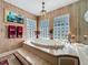 Elegant bathroom with a soaking tub, decorative wallpaper, glass block windows, and gold fixtures at 254 Sylvan Blvd, Winter Park, FL 32789