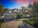 Stunning exterior view of home featuring a three-car garage and meticulously landscaped front yard with paver driveway at 254 Sylvan Blvd, Winter Park, FL 32789