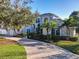 Beautiful facade with palm trees, well-manicured landscaping, and paver driveway leading to the garage and front entrance at 254 Sylvan Blvd, Winter Park, FL 32789