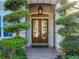 Elegant front entrance featuring a decorative glass double door, stone accents, and manicured landscaping at 254 Sylvan Blvd, Winter Park, FL 32789