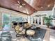 Inviting living area with a wood ceiling, comfortable seating, stone fireplace, and views of the pool at 254 Sylvan Blvd, Winter Park, FL 32789