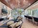 Elegant living area featuring wood ceilings, a stone fireplace, views to the water, and a bar with seating at 254 Sylvan Blvd, Winter Park, FL 32789